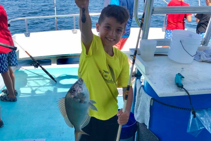 a young boy holding a fish